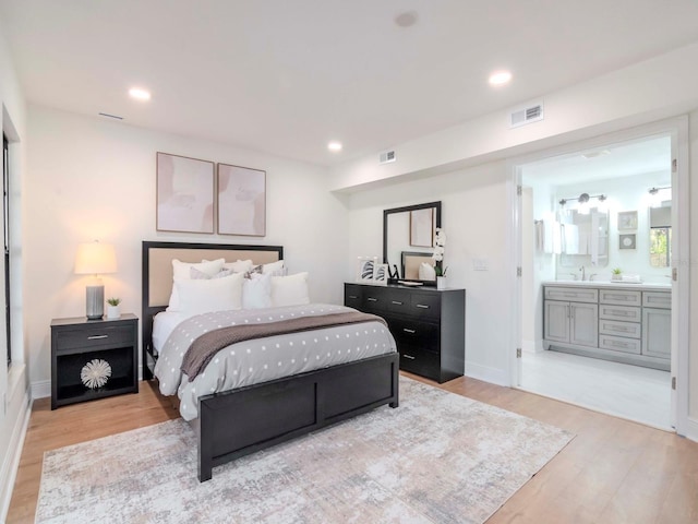 bedroom featuring connected bathroom, recessed lighting, a sink, wood finished floors, and visible vents