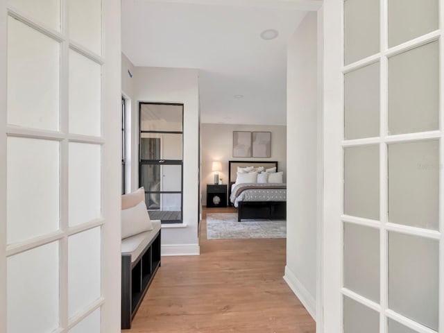 corridor featuring baseboards and light wood-style floors