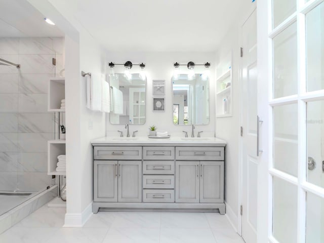 bathroom featuring a sink, a shower stall, baseboards, and double vanity