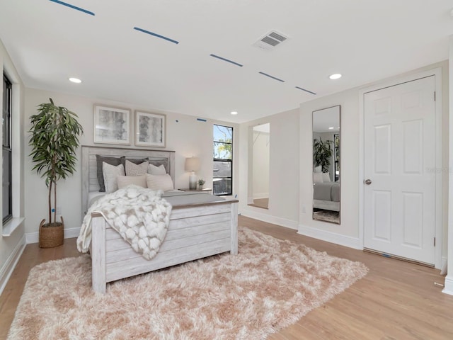 bedroom with recessed lighting, light wood-type flooring, visible vents, and baseboards