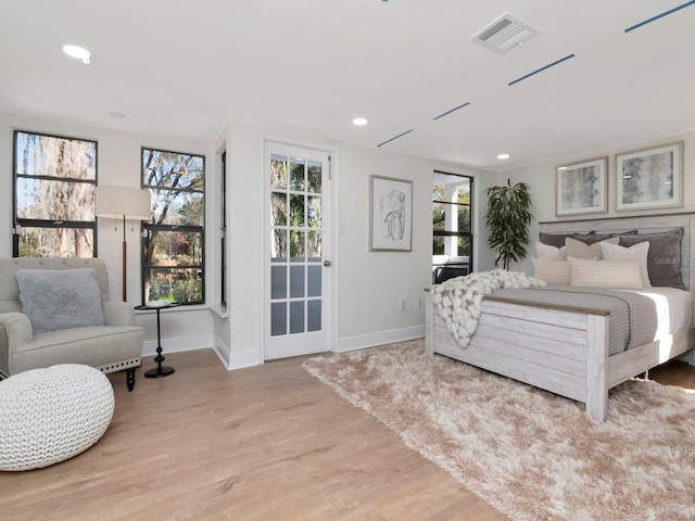 bedroom with baseboards, visible vents, wood finished floors, and recessed lighting