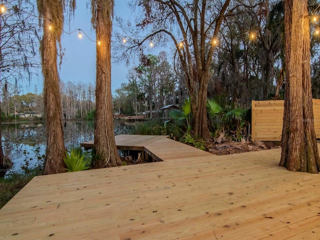 wooden terrace with a dock and a water view