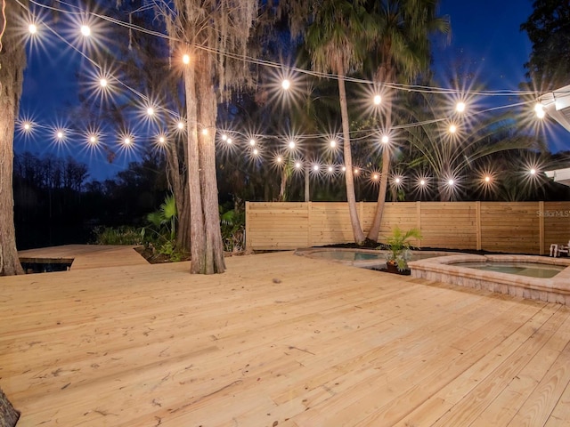 exterior space featuring an in ground hot tub and fence