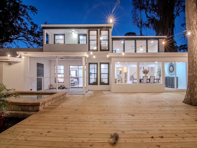 back of house at night with stucco siding