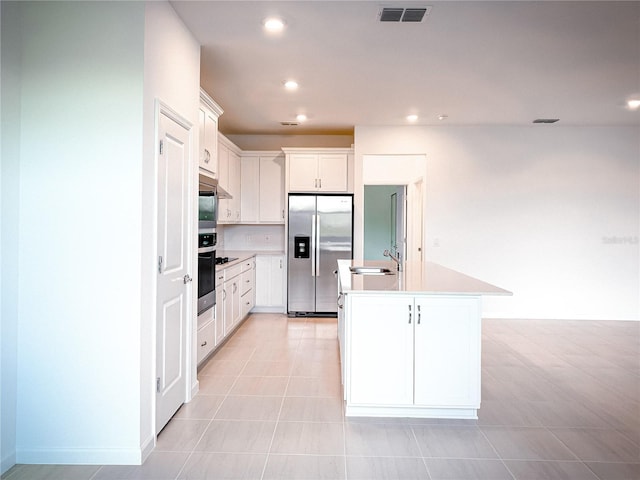 kitchen with visible vents, a center island with sink, recessed lighting, appliances with stainless steel finishes, and a sink