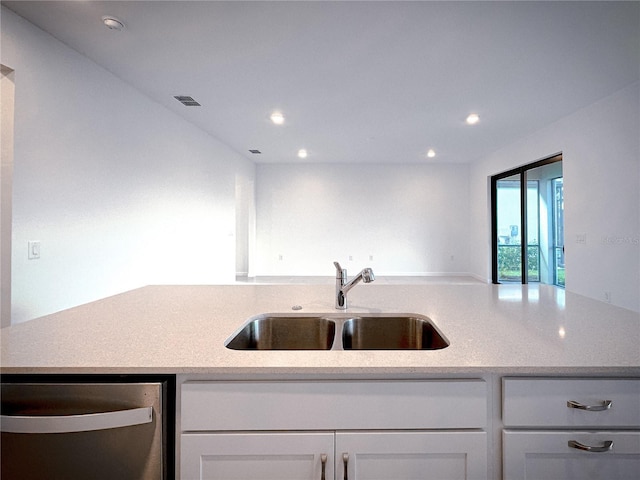 kitchen with light stone counters, recessed lighting, a sink, white cabinets, and dishwasher