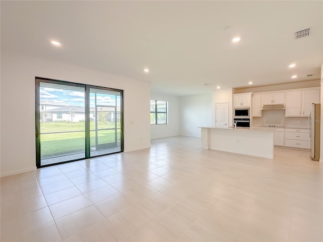 unfurnished living room with light tile patterned floors, visible vents, recessed lighting, and baseboards