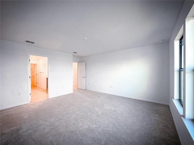 carpeted empty room with baseboards and visible vents