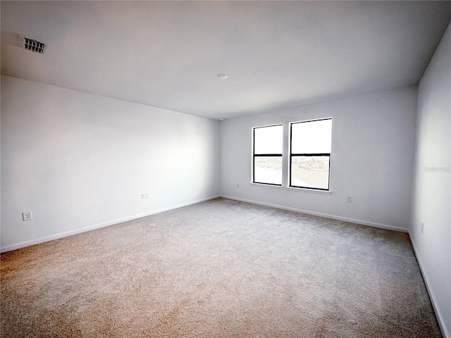 carpeted spare room featuring visible vents and baseboards