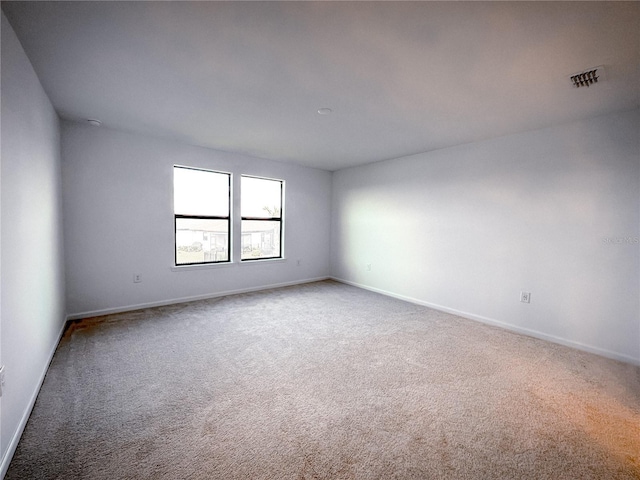 carpeted empty room with baseboards and visible vents