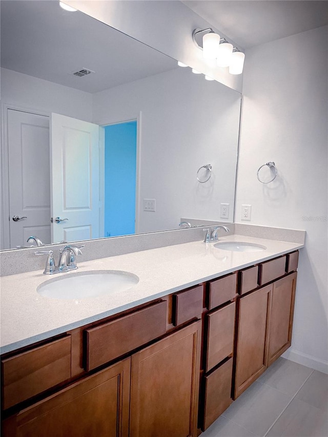 bathroom with double vanity, visible vents, and a sink