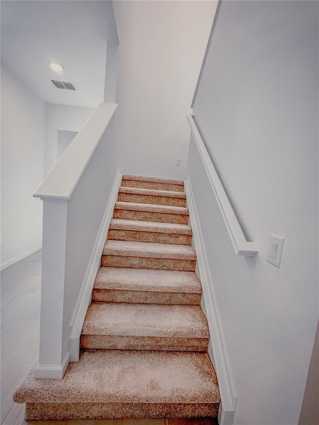 stairs featuring baseboards and visible vents