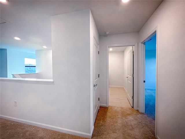 hallway with baseboards and carpet floors