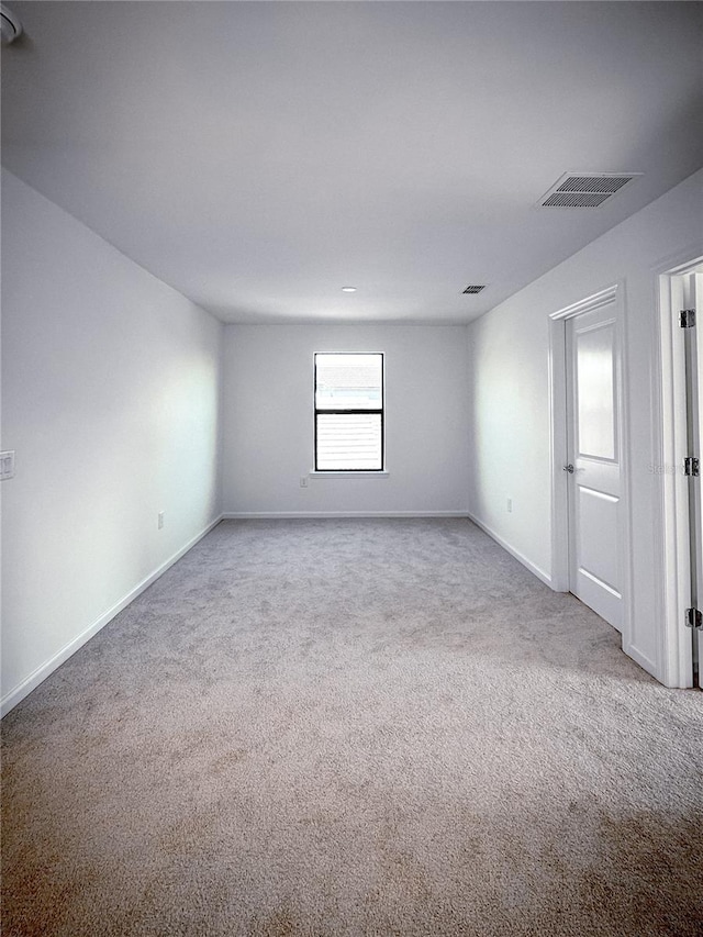 carpeted empty room with visible vents and baseboards