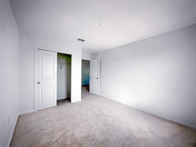 unfurnished bedroom with a closet, visible vents, baseboards, and carpet floors