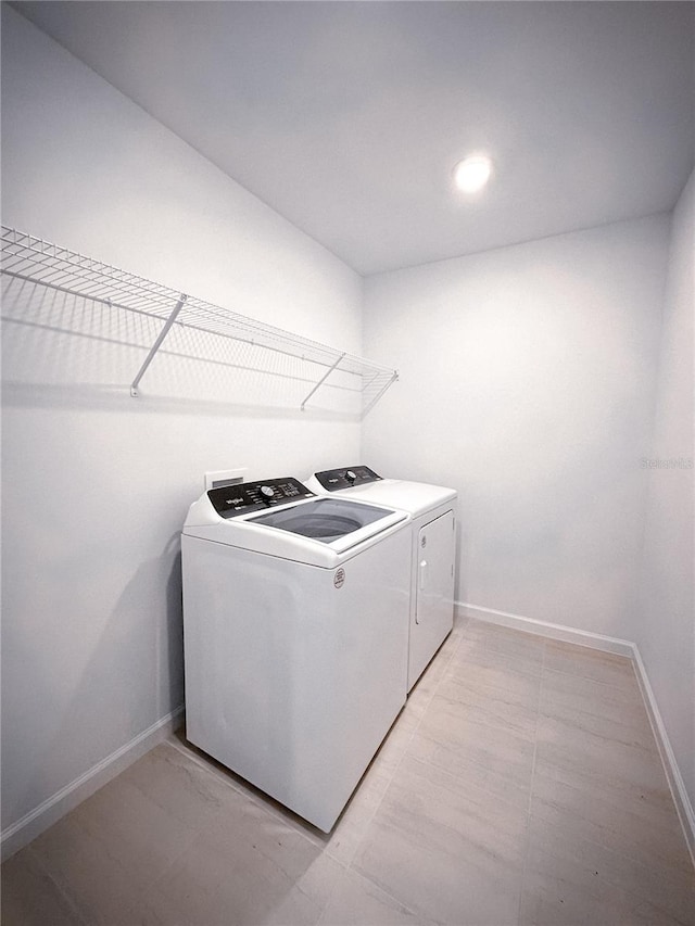 laundry room featuring baseboards, washing machine and dryer, and laundry area