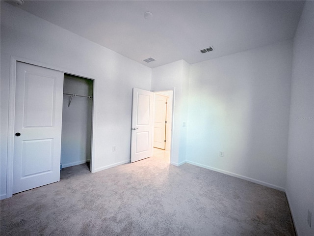 unfurnished bedroom with a closet, visible vents, baseboards, and carpet floors