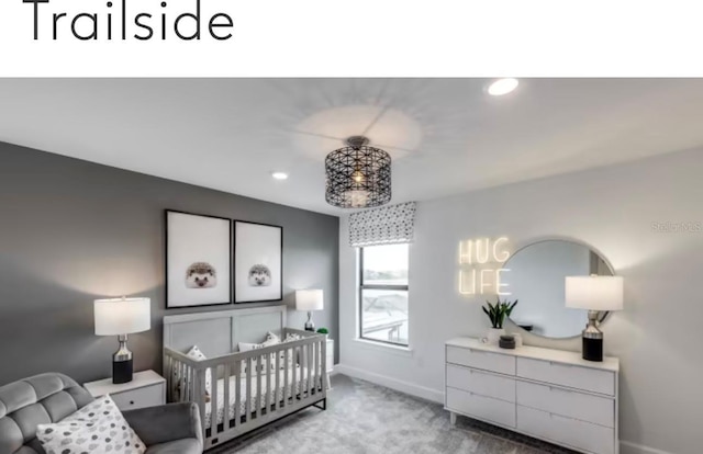 bedroom featuring recessed lighting, a nursery area, baseboards, and carpet