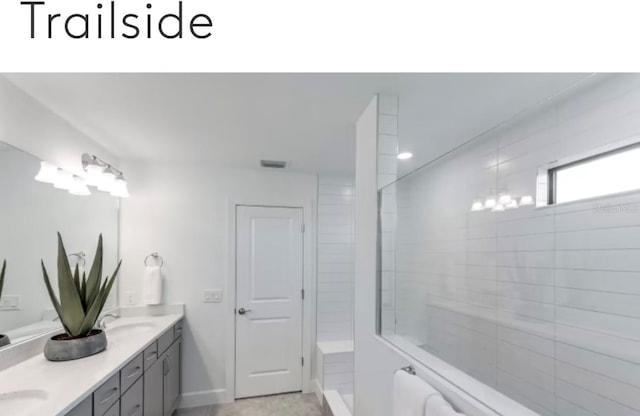 bathroom featuring double vanity, visible vents, a tile shower, and a sink