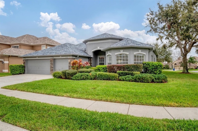 view of front of home with stucco siding, concrete driveway, a garage, stone siding, and a front lawn