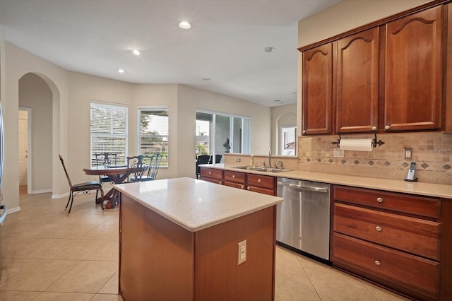 kitchen featuring dishwasher, tasteful backsplash, light tile patterned floors, and a sink