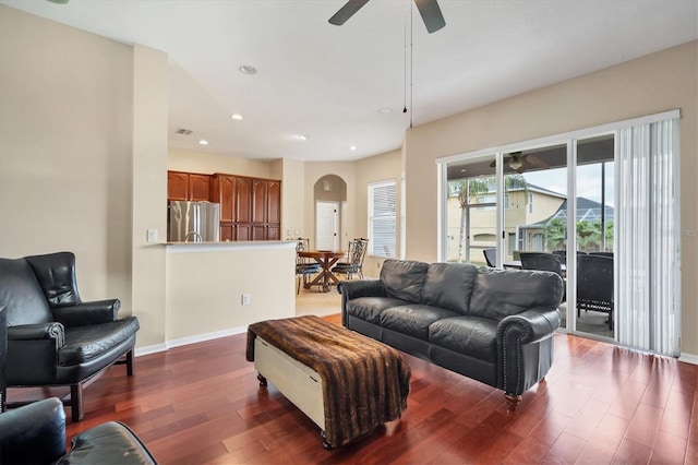 living area featuring arched walkways, ceiling fan, recessed lighting, wood finished floors, and baseboards