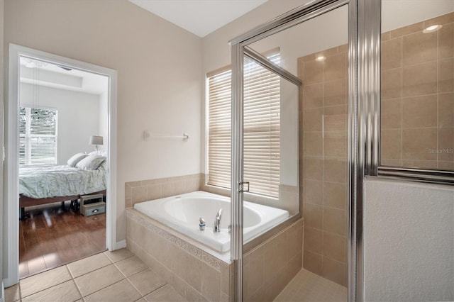 full bathroom featuring tile patterned floors, a garden tub, tiled shower, and ensuite bathroom