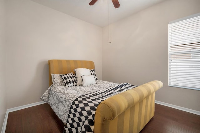 bedroom featuring multiple windows, baseboards, and wood finished floors