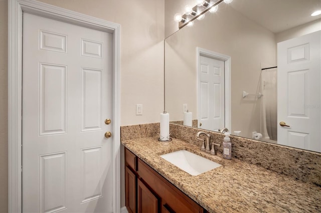 bathroom featuring walk in shower and vanity