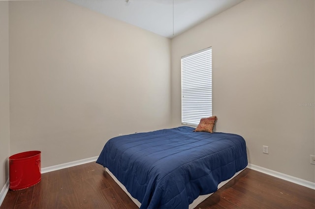 bedroom featuring baseboards and wood finished floors