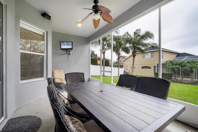 sunroom / solarium featuring lofted ceiling and ceiling fan