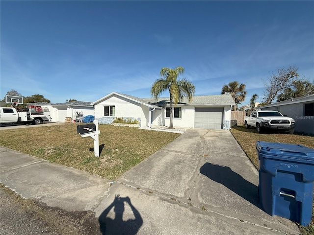 single story home featuring a front yard, driveway, an attached garage, and stucco siding