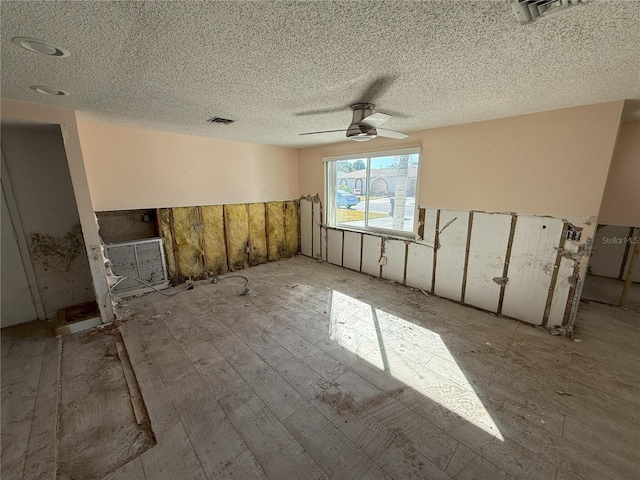 empty room featuring a textured ceiling, visible vents, and a ceiling fan