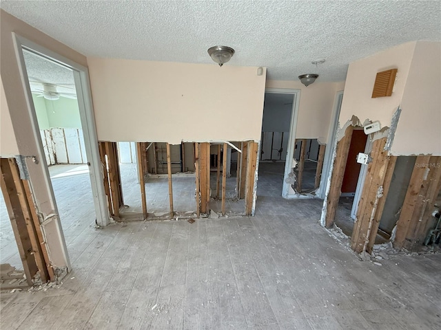 empty room featuring a textured ceiling and wood finished floors