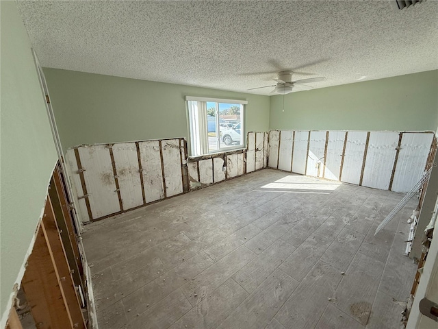 empty room featuring a textured ceiling, visible vents, and a ceiling fan