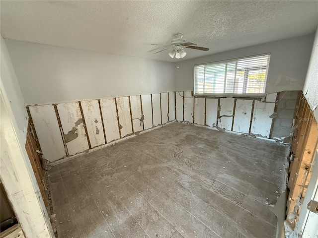 empty room with ceiling fan, a textured ceiling, and wood finished floors