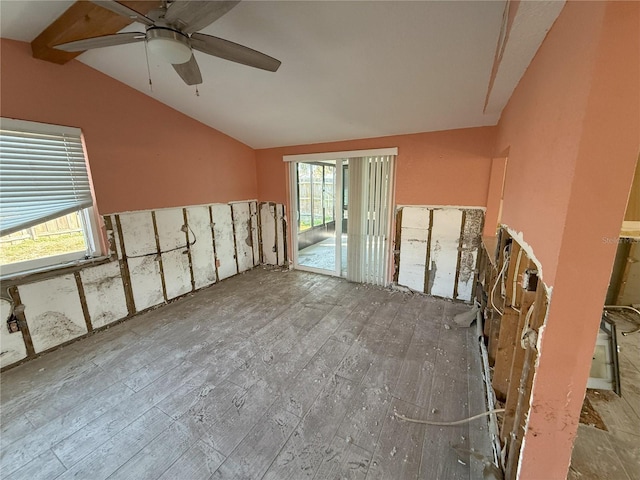 spare room featuring lofted ceiling with beams and a ceiling fan