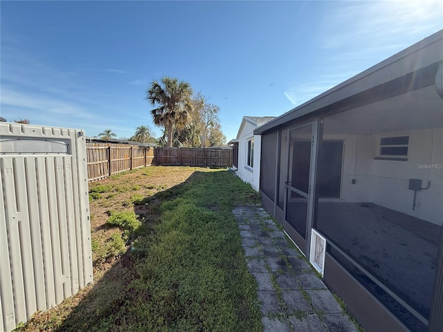 view of yard with a fenced backyard and a sunroom