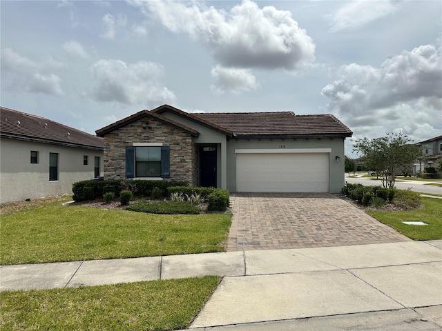 ranch-style home with a garage, stone siding, a tiled roof, decorative driveway, and a front lawn