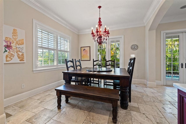 dining area with arched walkways, stone tile flooring, an inviting chandelier, ornamental molding, and baseboards