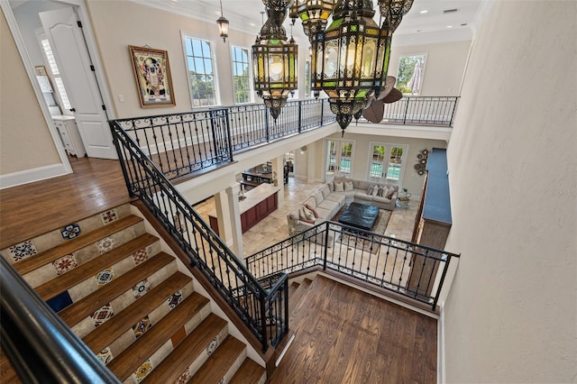 staircase featuring a healthy amount of sunlight, an inviting chandelier, and wood finished floors