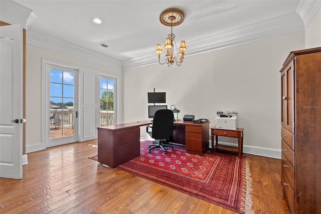 office area featuring a notable chandelier, visible vents, baseboards, ornamental molding, and wood-type flooring