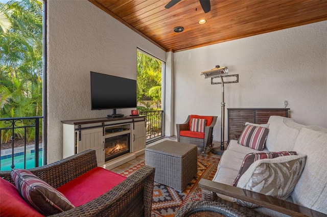 living room featuring recessed lighting, a textured wall, a glass covered fireplace, wood ceiling, and ceiling fan