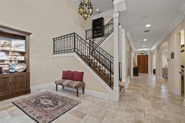 foyer with arched walkways, stone tile flooring, visible vents, and baseboards