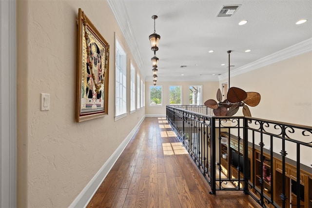 hallway featuring baseboards, visible vents, dark wood finished floors, and crown molding