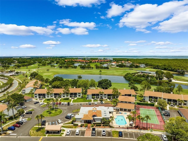 drone / aerial view with view of golf course and a water view