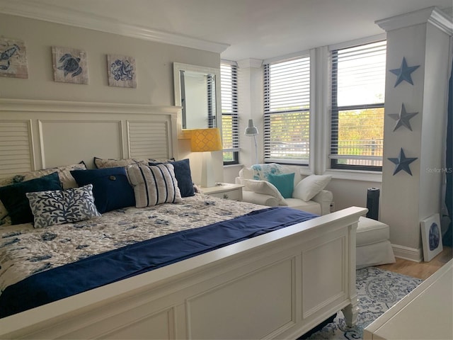 bedroom with crown molding and light wood finished floors