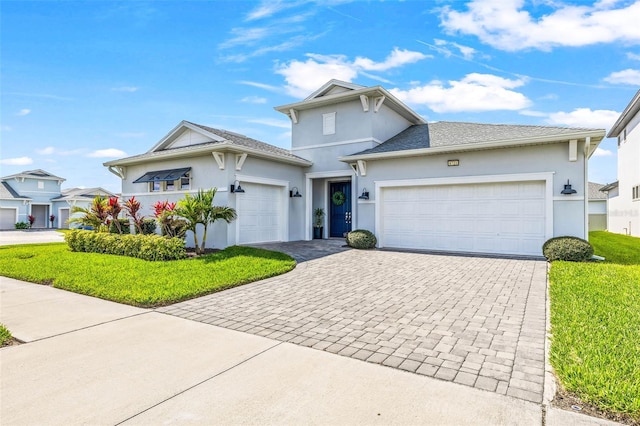 view of front facade with an attached garage, decorative driveway, and stucco siding