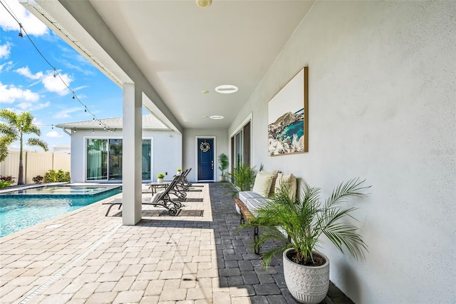 view of patio featuring a fenced in pool, fence, and an in ground hot tub