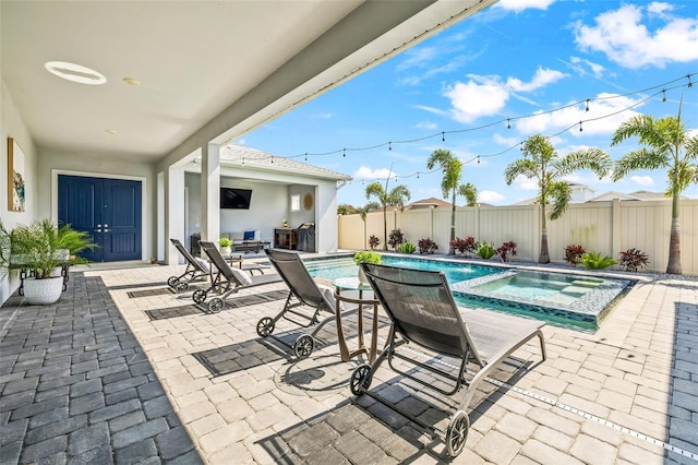 view of swimming pool featuring a pool with connected hot tub, a patio area, and a fenced backyard